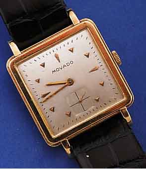 MOVADO HERRENARMBANDUHR, SCHWEIZ UM 1936, GG 585/000, CARREE-ARRONDE-FORM, LüNETTE GE- ST., BODEN GEDR., BLATT REST., RUNDANKERW., 16 ST., ...