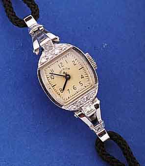 LADY ELGIN DAMENARMBANDUHR, PLATIN/IRIDIUM- GEH., USA UM 1950, LüNETTE SOWIE BANDANST. M. DIAMANTBES., BODEN GEDR., ORIG.-BLATT U. ZEI- GER, ...