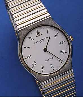 BAUME BAUME & MERCIER ARMBANDUHR MEDIUM QUARTZ, SCHWEIZ UM 1990, EDELST., FLACHE AUSF., EDEL- ST.-BAND, ZWISCHENGL. HARTVERG., SAPHIRFLACH- GL., ...