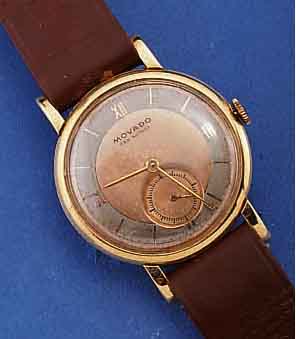 MOVADO HERRENARMBANDUHR, SCHWEIZ UM 1938, GG 750/000, BODEN U. GLASR. GEDR., KUPFERFARB. ORIG.-BLATT FL., KL. SEK. VERT., AUßER LEDERB. U. KRONE ...