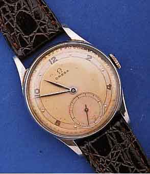 OMEGA HERRENARMBANDUHR, SCHWEIZ UM 1948, EDELST., BOD. U. GLASRAND AUFGED., 2FARB. VER- SILB. BL., KAL. 30T2, VERG., 15 ST., HAND- AUFZ., ...