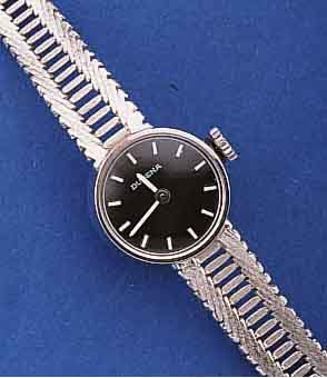 DUGENA DAMENGOLDBANDUHR, DEUTSCHLAND UM 1968, WG 585/000-GEH. INCL. BAND RHOD., BODEN GEDR., SCHWARZES KONTRASTZIFFERBL., FORMANKER- W., 17 ST., ...