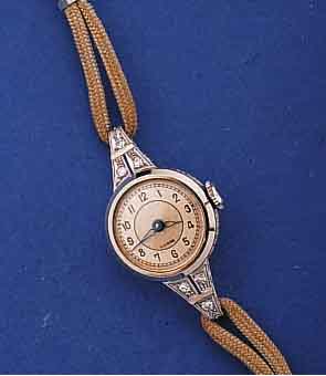 DAMENGOLDUHR ART DECO, SCHWEIZ/DEUTSCHLAND UM 1938, WG 585/000 GEH., BODENSCHARNIER, KORDELBANDANSTÖßE MIT DIAMANTBES., 2-FARBIG VERS. BL., ...