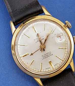 MILUS ARMBANDWECKER, SCHWEIZ UM 1955, METALL VERCHR., BER., EDELST.BOD. GESCHR., DAT., 21 ST., INCABL., GEH- U. WECKWERK, EINFEDERHAUS, BASISKAL. ...