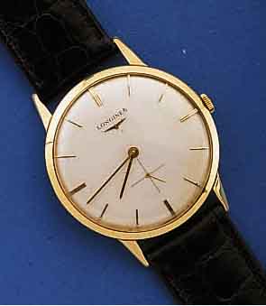 LONGINES HERRENGOLDUHR, SCHWEIZ UM 1957, GG 750/000, FLACHE AUSF., BOD. U. GLASRAND AUFGE- DR., VERSILB. BL. ZUM RAND ZU LT. FARBL. GE- TÖNT, ...