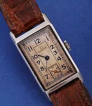 OMEGA ARMBANDUHR, SCHWEIZ UM 1936, EDELST., RECT.-FORM IN GEHOB. QUALITÄT (PASSFORM), LE- DERBD. SPÄTER, ORIG. BL. VERSILB., ALTERSBED. FARBL. ...