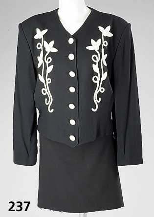 NORMA-KAMALI-Kurzweste, Viskose/Acetat, schwarz mit aufgenÄhter wollweißer Blumen- applikation, ital. Gr. 48, 7 KnÖpfe, RÜcken- l. ca. 56 cm