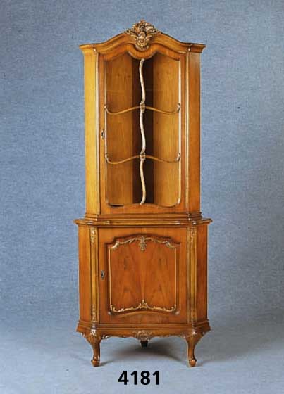 Eckvitrine, deutsch, um 1970, Warrings, Hei- delberg, Nußbaum massiv, Nußbaumfurnier gespiegelt, Verzierung Bildhauerarbeit, z.T. aus dem ...
