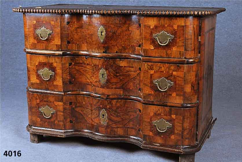 Doppelt geschweifte Kommode, Braunschweig, um 1730, Korpus Weichholz, Nußbaum-, Wurzelnuß- , Mahagoni- und Ebenholzfurnier, Mittelteil in sich ...