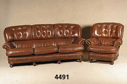 Sitzgarnitur, wohl deutsch, um 1960, Leder, bestehend aus Sofa und 2 Sessel, RÜcken ge- heftet und genoppt, lose Kissen, Schauteile Nußbaum ...