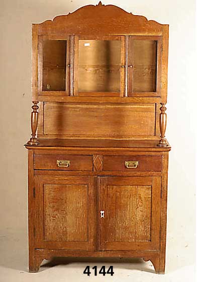 SÄulenbuffetschrank, deutsch, um 1920, Eiche u. Weichholz, Oberteil 3-tÜrig verglast, geo- metrisch geschwungene, spitzzulaufende Form, viele ...