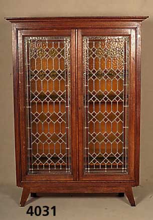 Kleiner BÜcherschrank, deutsch, um 1920, 2-tÜrig, mit aufwendiger Bleiverglasung in grÜn, rot und gelb, in Rautenform, Glas stel- lenweise mit ...