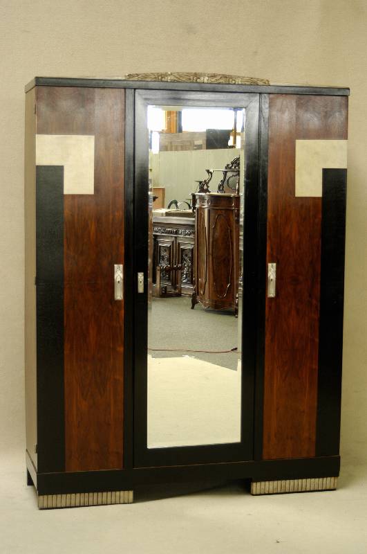 ArtDeco-Schrank, Frankreich, um 1920, kau- kasischer Nußbaum, gespiegelt furniert, Sockel und Kranz ebonisiert sowie partiell versilbert, ...