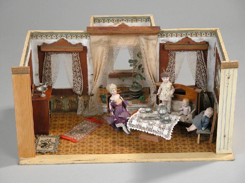 Puppenstube, deutsch, um 1890/1900, mit Sofa, Tisch und zwei StÜhlen, Vertiko, HolzmÖbel, vier PorzellanpÜppchen z.T. besch. mit alten Tapeten, ...