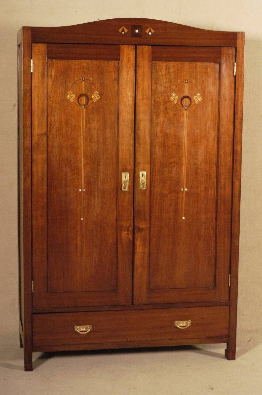 Schrank, wohl deutsch, um 1910, Nußbaumfur- nier, zweitÜrig, Sockelschublade, in den TÜren und im oberen Abschluß floral stilisierte Intarsien ...