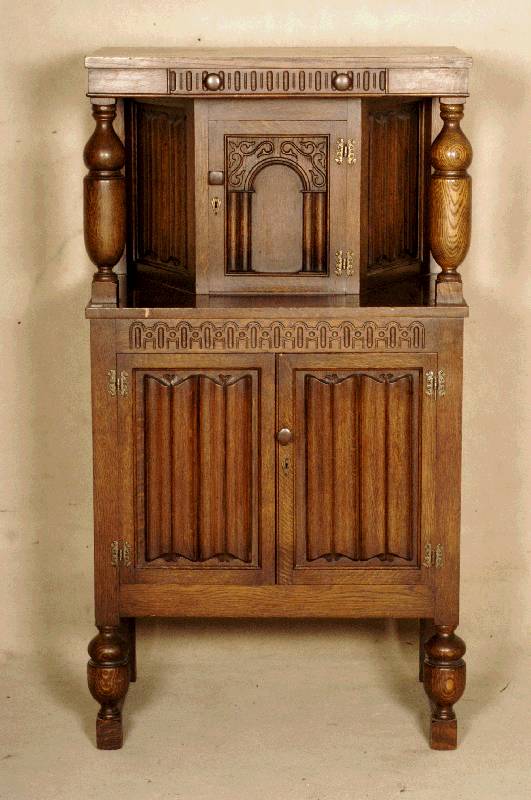 Kleiner Vielzweckschrank, England, um 1930, Eiche massiv, geometrische Kerbschnitzerei, zwei freistehende SÄulen (gedrechselt), dreitÜrig, mit ...