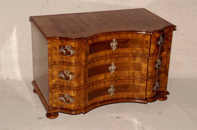 Doppelt geschweifte Kommode, Barockstil, Front horizontal aufgebaut dickes Nußbaum- bzw Pflaumenfurnier, Bandintarsien, z.T. rhomboid eingelegt, ...