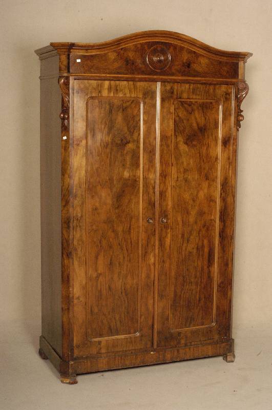 Kleiderschrank, deutsch, um 1880, Nußbaum massiv, Wurzelnußfurnier, zweitÜrig im profilierten Rahmen gefaßt, Kopfteil geschwungene Form mit ...