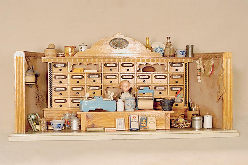 Kaufmannsladen, deutsch, um 1910/20, HolzgehÄuse, versch. Miniaturverpackungen, 1 SchildkrÖtpÜppchen, viele GefÄße und Flaschen, eine Waage, ...