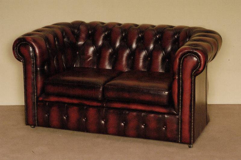 2-sitzer Sofa, England, Chesterfield, roter Lederbezug, genoppt und geheftet, auf Rollen, lose Kissen, leichte Gebrauchsspuren, ca. 71x138x82 cm, ...