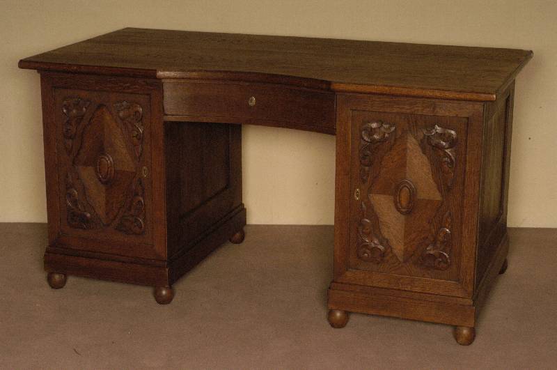 Schreibtisch, deutsch, um 1910, Eiche massiv, z.T. Eichefurnier, auf KugelfÜßen, TÜrfÜllungen mit Schnitzereien, vorstellende ...