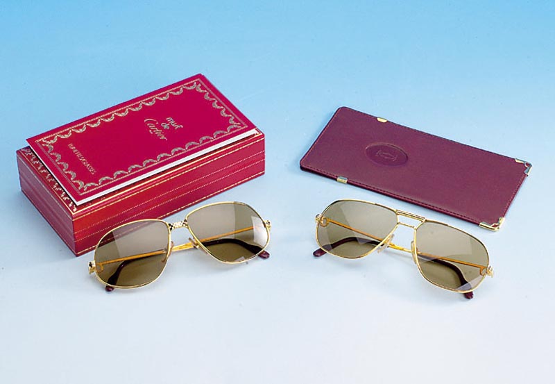 CARTIER Sonnenbrille im orig. Etui, Gestell vergoldet, bordeauxrote BÜgelabschlÜsse mit Cartiersigneten an den Enden, getÖnte GlÄser, im orig. ...