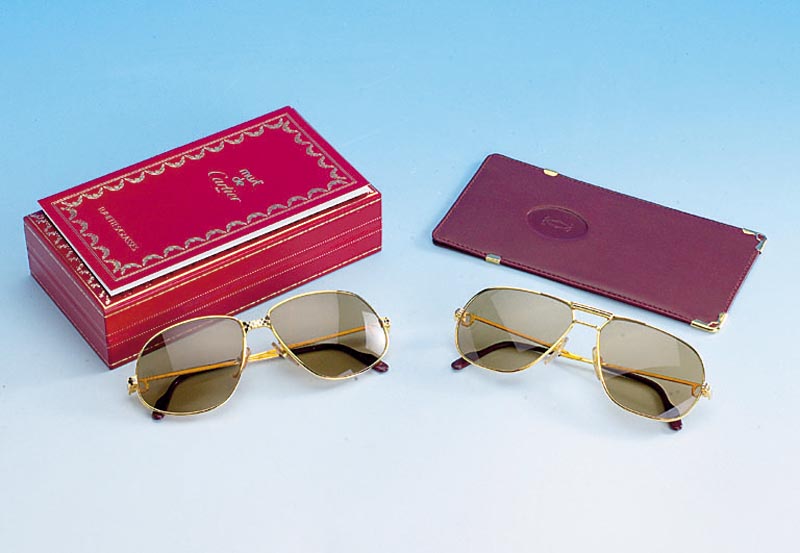 CARTIER Sonnenbrille im orig. Etui, Gestell vergoldet, BÜgelabschlÜsse bordeauxrot mit aufgesetzten Cartiersigneten, minimal getÖnt, mit orig. ...