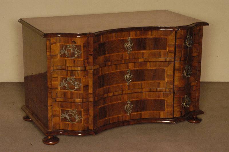 Doppelt geschweifte Kommode, Barockstil, Front horizontal aufgebaut, dickes Nußbaum- bzw. Pflaumenfurnier, Bandintarsien, z.T. rhomboid ...