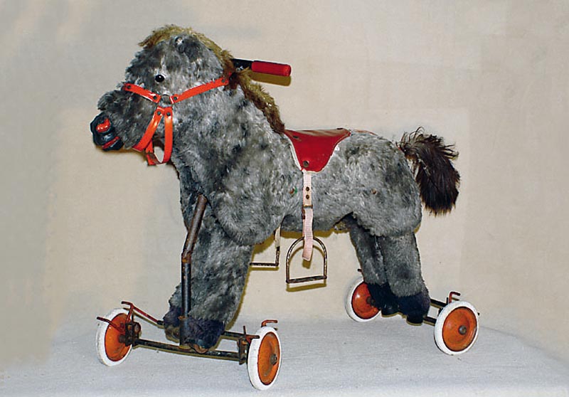 Pferd auf Rollen, 30er/40er Jahre, Steiff (?), grauer Webpelz, altersbed. bespielt, Gestell korrodiert, z.T. besch., Sitzh. ca. 50 cm, selten