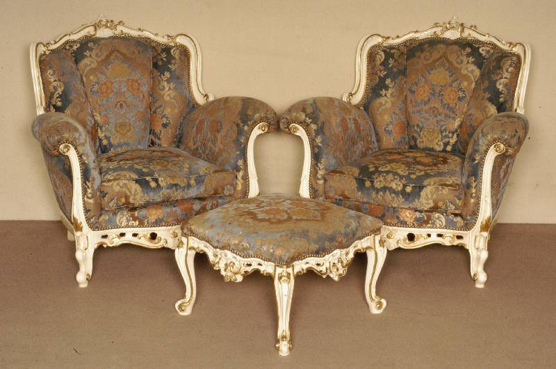2 Sessel und Hocker, Italien, 70er Jahre, massiv Linde/Buche, in sich vielfach geschweift, im Rokokostil, asymetrisch angeordnet, cremefarben ...
