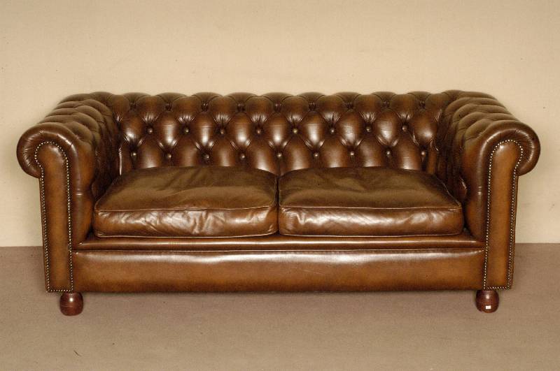 2-sitzer Sofa, England, im Chesterfieldstil, brauner gehefteter Rindslederbezug, herausnehmbare Kissen, Gebrauchsspuren, ca. 70x185x81 cm, Sh. 45 ...