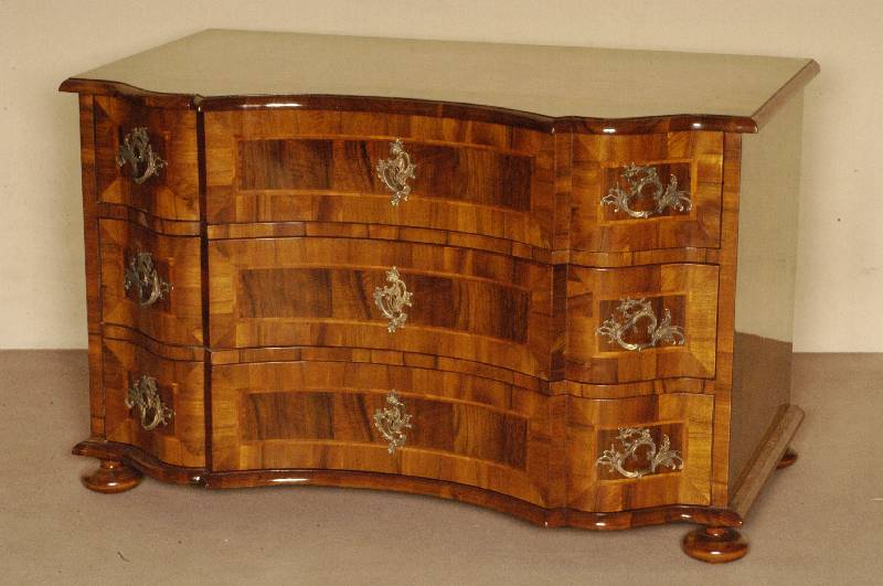 Doppelt geschweifte Kommode, Barockstil, Front horizontal aufgebaut, dickes Nußbaum- bzw. Pflaumenfurnier, Bandintarsien, z.T. rhomboid ...