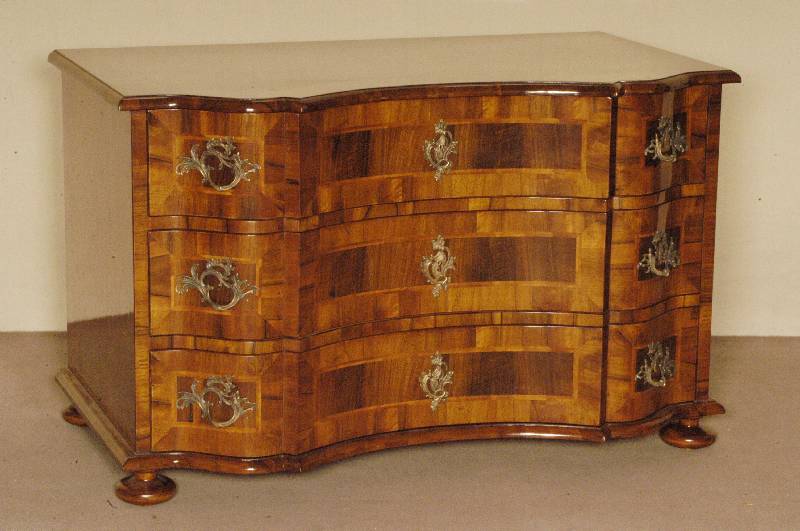 Doppelt geschweifte Kommode, Barockstil, Front horizontal aufgebaut, dickes Nußbaum- bzw. Pflaumenfurnier, Bandintarsien, z.T. rhomboid ...