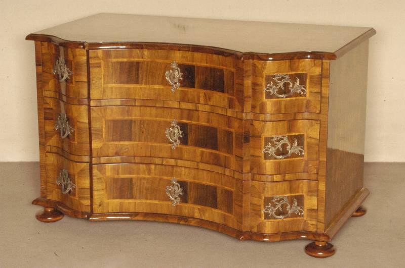 Doppelt geschweifte Kommode, Barockstil, Front horizontal aufgebaut, dickes Nußbaum- bzw. Pflaumenfurnier, Bandintarsien, z.T. rhomboid ...