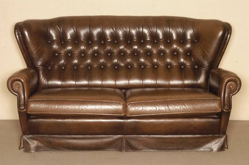 Ledersofa, im englischen Stil, wohl um 1970, braunes Rindsleder, RÜckenlehne geheftet und genoppt, lose Kissen, Gebrauchsspuren, ca. 89x166x88 cm, ...