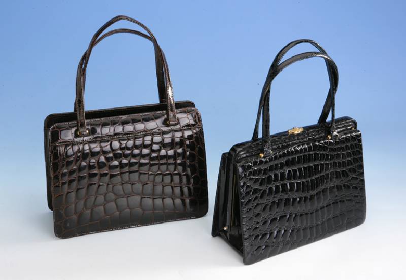 Konvolut 2 Krokotaschen, dunkelbraun/ schwarz, Tragegriffe, Monturen Metall vergoldet, Gebr.-Spuren, Inneneinrichtung, ca. 18 x 23 cm