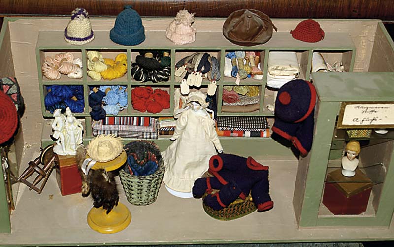 Stoffladen, um 1900, Holz, z.T. verglast, sehr reich u. liebevoll mit HÜtchen, Wolle etc. eingerichtet, ca. 29x66x26cm, selten, sammelw.