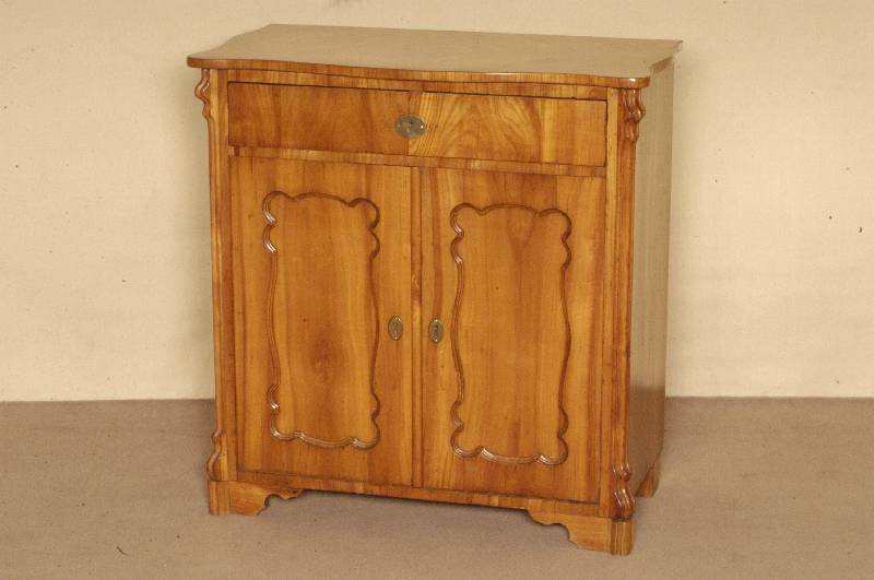 Halbschrank, deutsch, um 1860, Korpus Weichholz, Kirschbaumfurnier, z.T. gespiegelt, sogenannte BrezelfÜllungen, abgeplattete Seiten, aufgesetzte ...