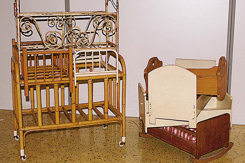 Konvolut vier Puppenbettchen, 1x Rattan mit Rollen, 1x Holz, 2x Metall (1x ohne Boden) , weiß gefasst; 1x mit Ornamenten; alle bespielt, ...