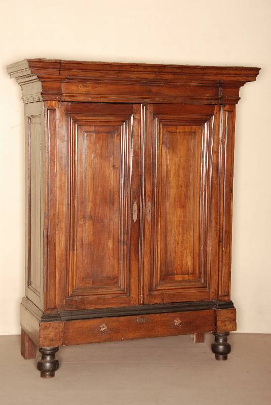 Schrank, Holland, um 1780, Nußbaum massiv, z.T. Eiche, auf balusterfÖrmigen FÜßen, 1 Schublade, Seiten und TÜrfÜllungen kassettiert , ...