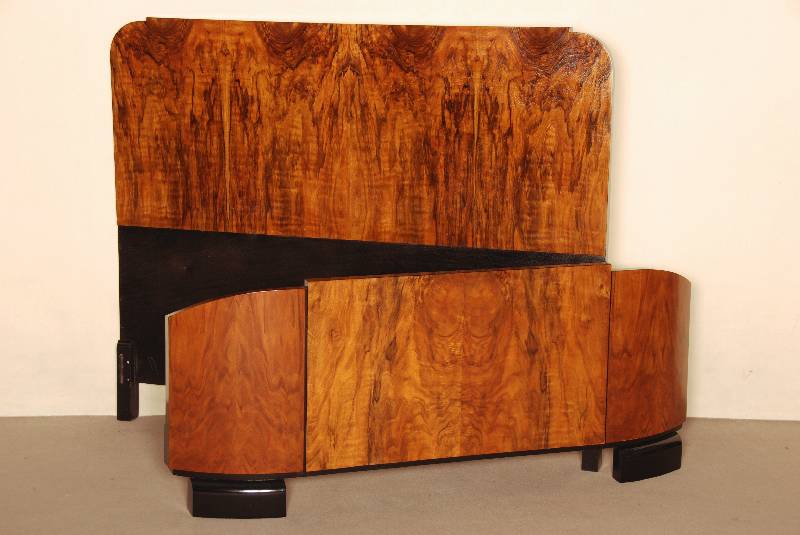 ArtDeco-Bett, Frankreich, um 1920, in kaukasisch Nußbaum gespiegelt furniert, zum Teil schwarz abgesetzt, Fußteil in elegantem Schwung dreifach ...