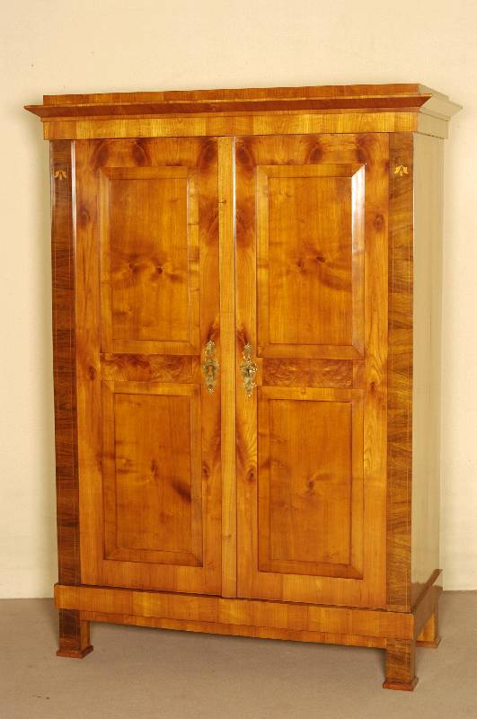 Biedermeierschrank, 2-tÜrig, Kirsche furniert, Lisenen Nußbaum furniert und intarsiert, durch Innenscharniere befestigte RahmentÜren mit je ...