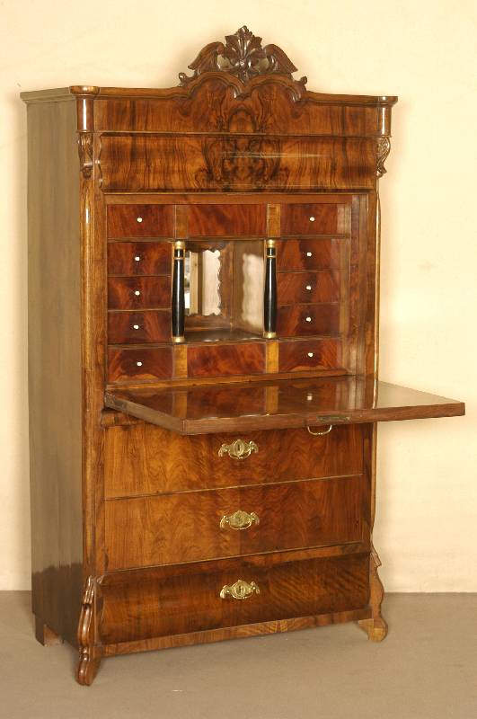 Louis-Philippe-StandsekretÄr, um 1850/60, sehr ansprechendes Nußbaum-Wurzelholz, Schnitzerei mittig im Kopfteil, gebauchter Kopfschub und ebenso ...