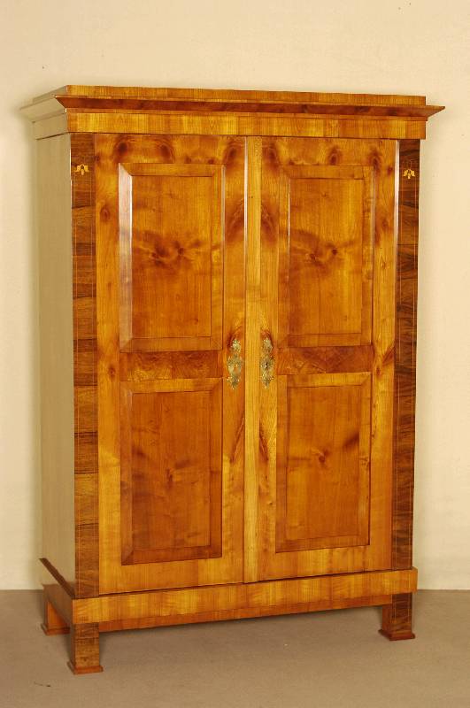 Biedermeierschrank, 2-tÜrig, Kirsche furniert, Lisenen Nußbaum furniert und intarsiert, durch Innenscharniere befestigte RahmentÜren mit je ...