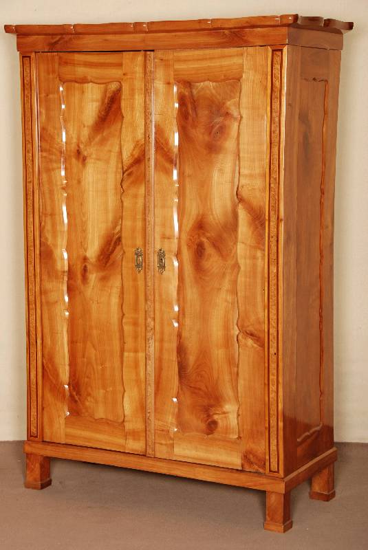 Kleiderschrank, deutsch um 1835/40, Kirschbaum massiv, BrezelfÜllungen, ausgewÄhltes Holz gespiegelt angeordnet, vertikale Streifeneinteilung in ...