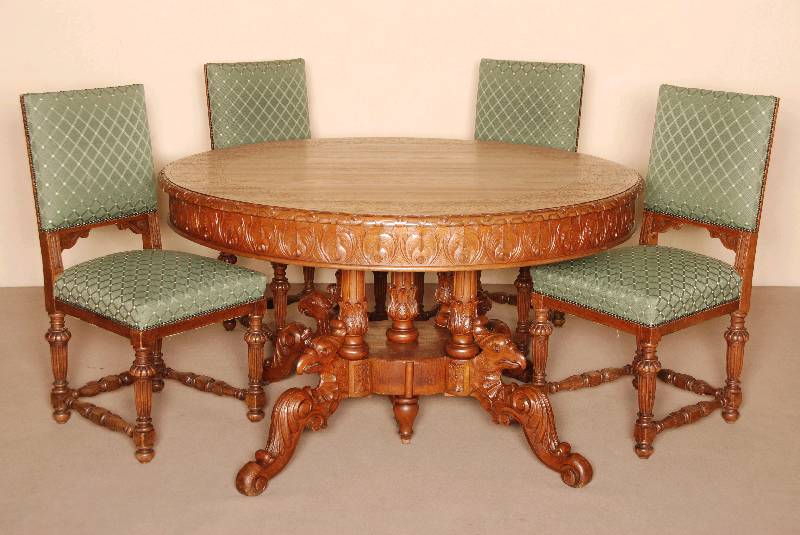 Tisch und 4 StÜhle, deutsch, um 1880, Eiche massiv, z.T. furniert, auf 4 gedrechselten SÄulen, 4-fach ausladend mit Greifvogelmotiv, Zarge ...