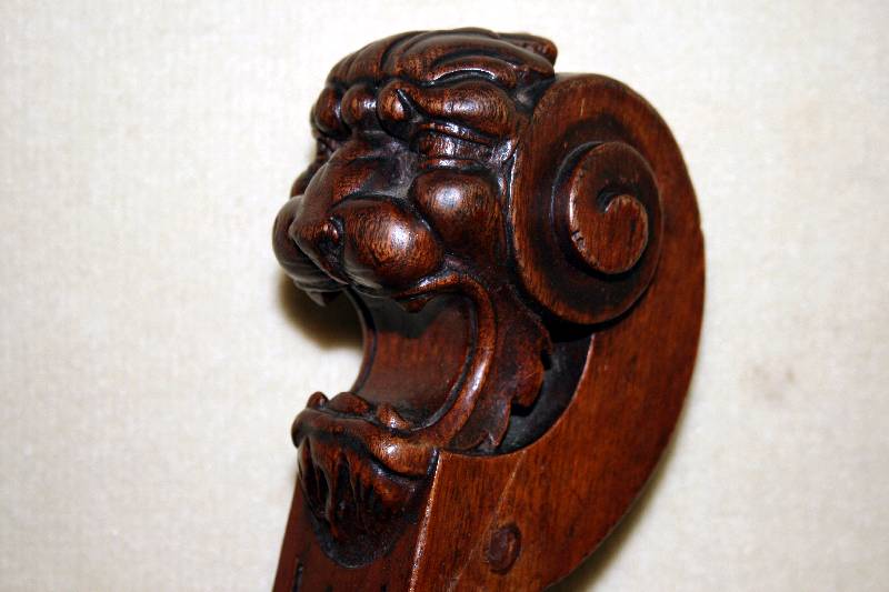 Detail a: Scheren- bzw. Dagobertsessel, deutsch, um 1880 , Nußbaum massiv, Front mit Schnitzereien, Lehnen dekoriert mit LÖwenkÖpfen, aus dem Vollholz ...