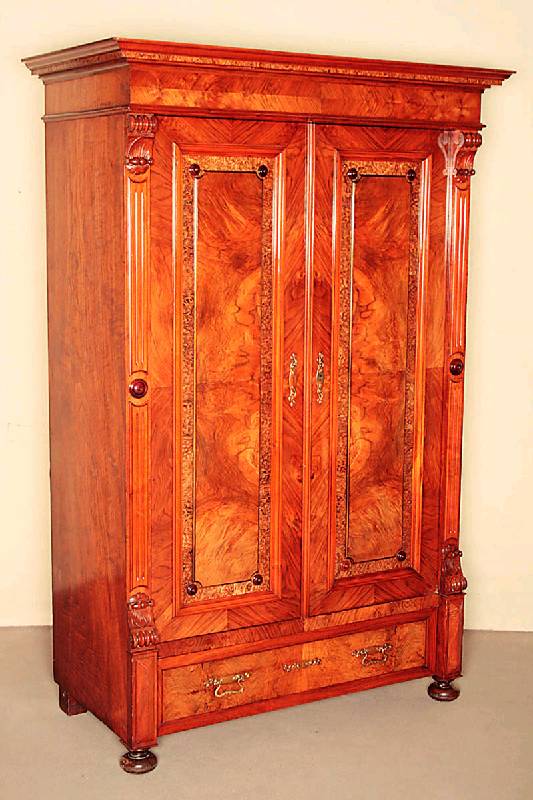 GrÜnderzeitschrank, deutsch, um 1880, Korpus Weichholz, Nußbaumfurnier, unten eine Schublade, TÜrfÜllungen kassettiert, Lisenen in Voluten ...