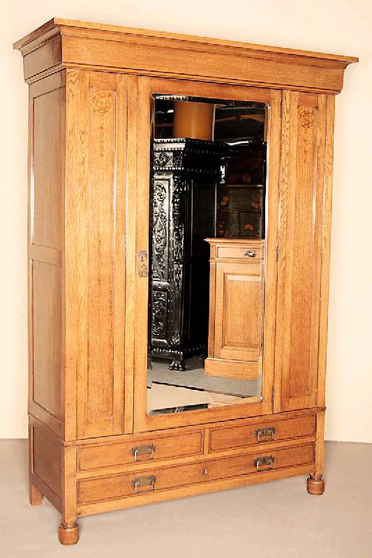 Garderobenschrank, Holland, um 1910, Amsterdamer Schule, Eiche massiv, auf Kugelfüßen, breite Zarge mit drei integrierten Schubladen, eintürig mit ...