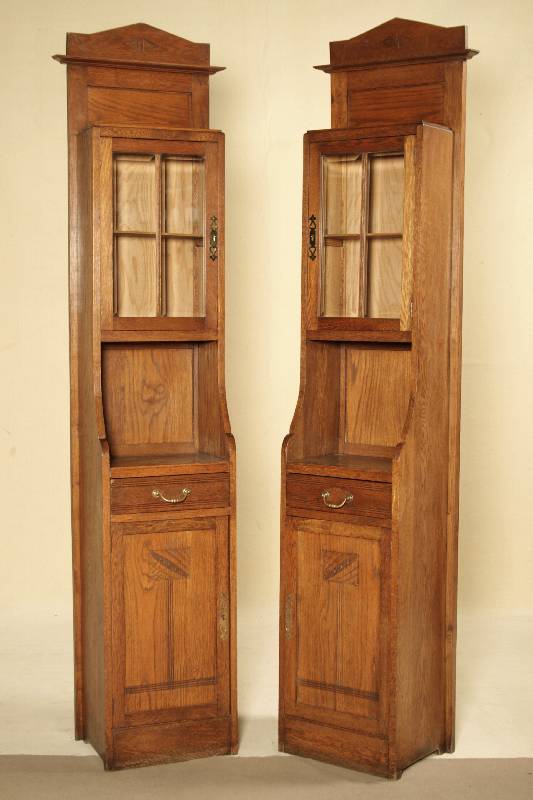 2 Pfeilervitrinen, wohl Karlsruhe, um 1905/10, Eiche massiv, Eichefurnier, Front auf Rahmen gearbeitet, facettierts Glas, Beschläge sek., integr. ...
